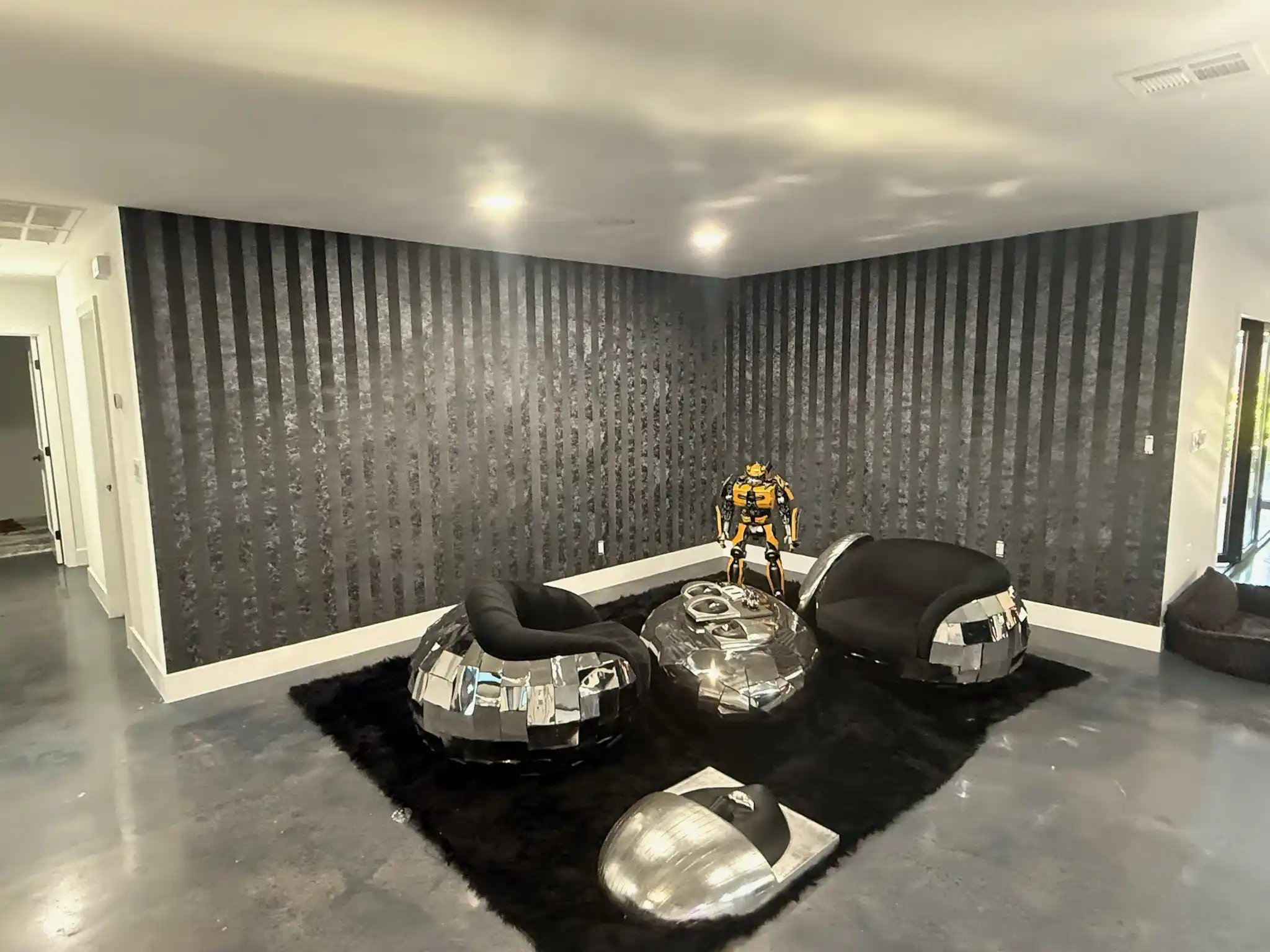 Dark geometric wallpaper on a modern living room wall